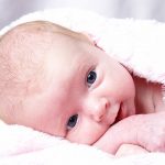 baby lying down and smiling